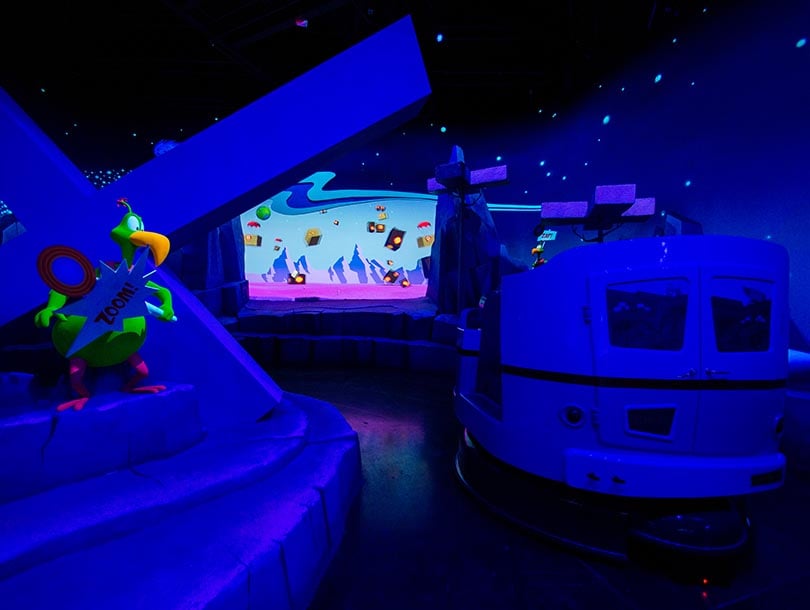 Dark ride carts moving through Ani-Mayhem at Warner Bros. World.