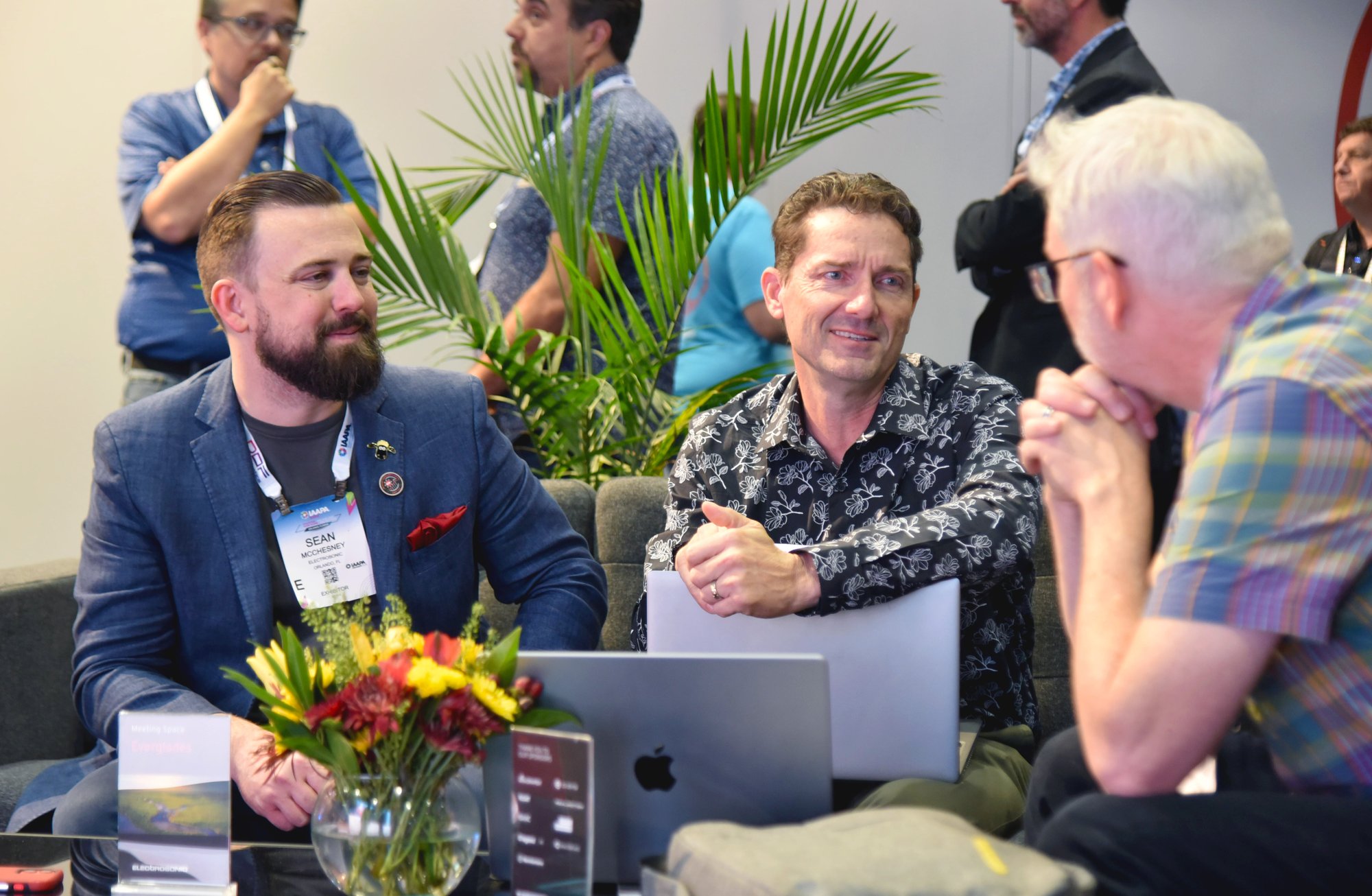 Two Electrosonic employees speaking with a potential customer at the IAAPA Expo.