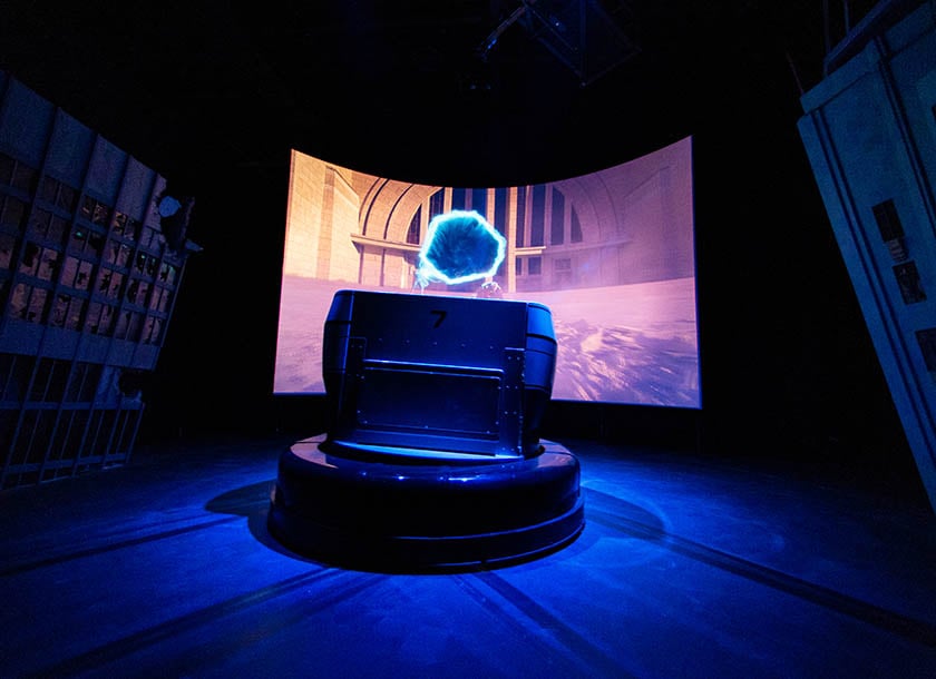 Ride vehicle parked in front of a screen at the Justice League Warworld Attack dark ride at Warner Bros. World Abu Dhabi.